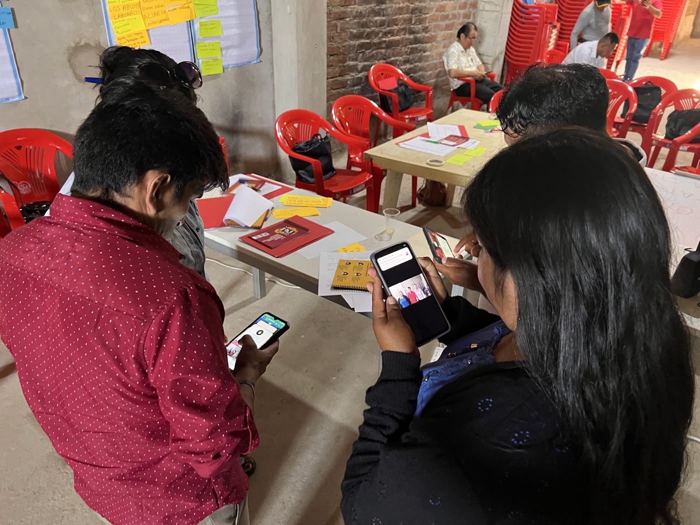 Union leaders look at social media posts on their phones during a workshop